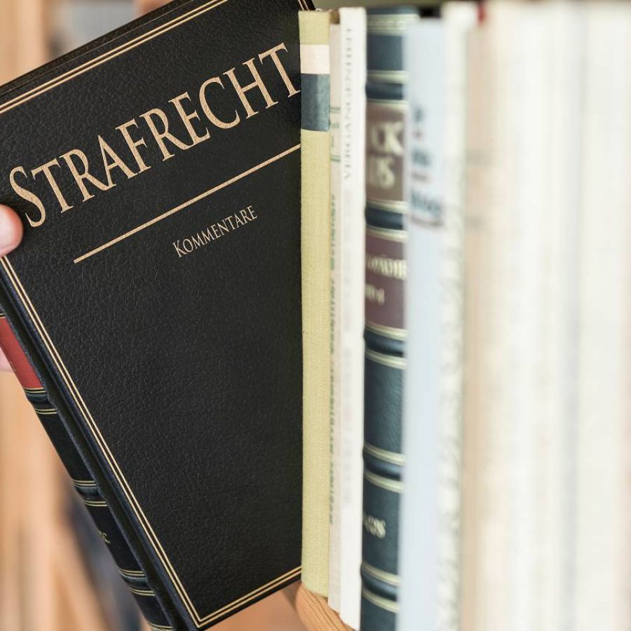 Strafrechtbuch wird aus Regal gezogen
